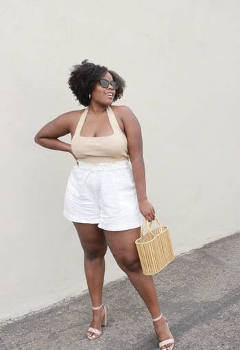 reviewer wearing top with white shorts and heels