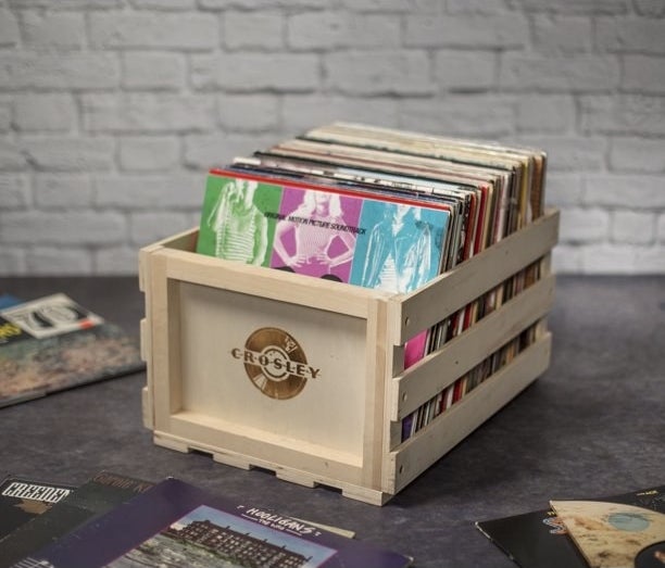 a wooden crate holding different vinyl albums
