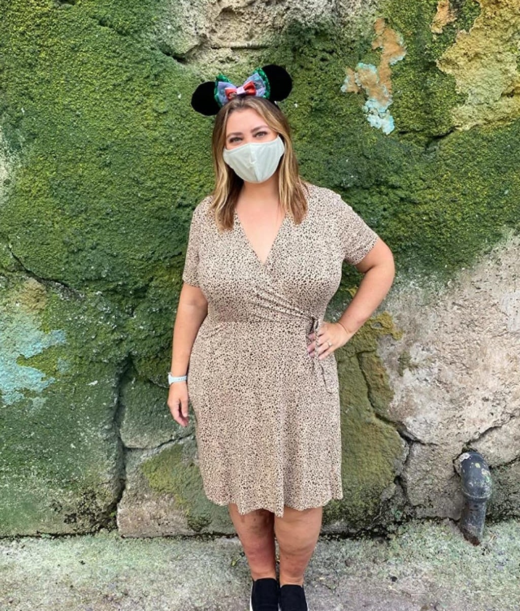 reviewer wearing the beige and black dress and mickey mouse ears