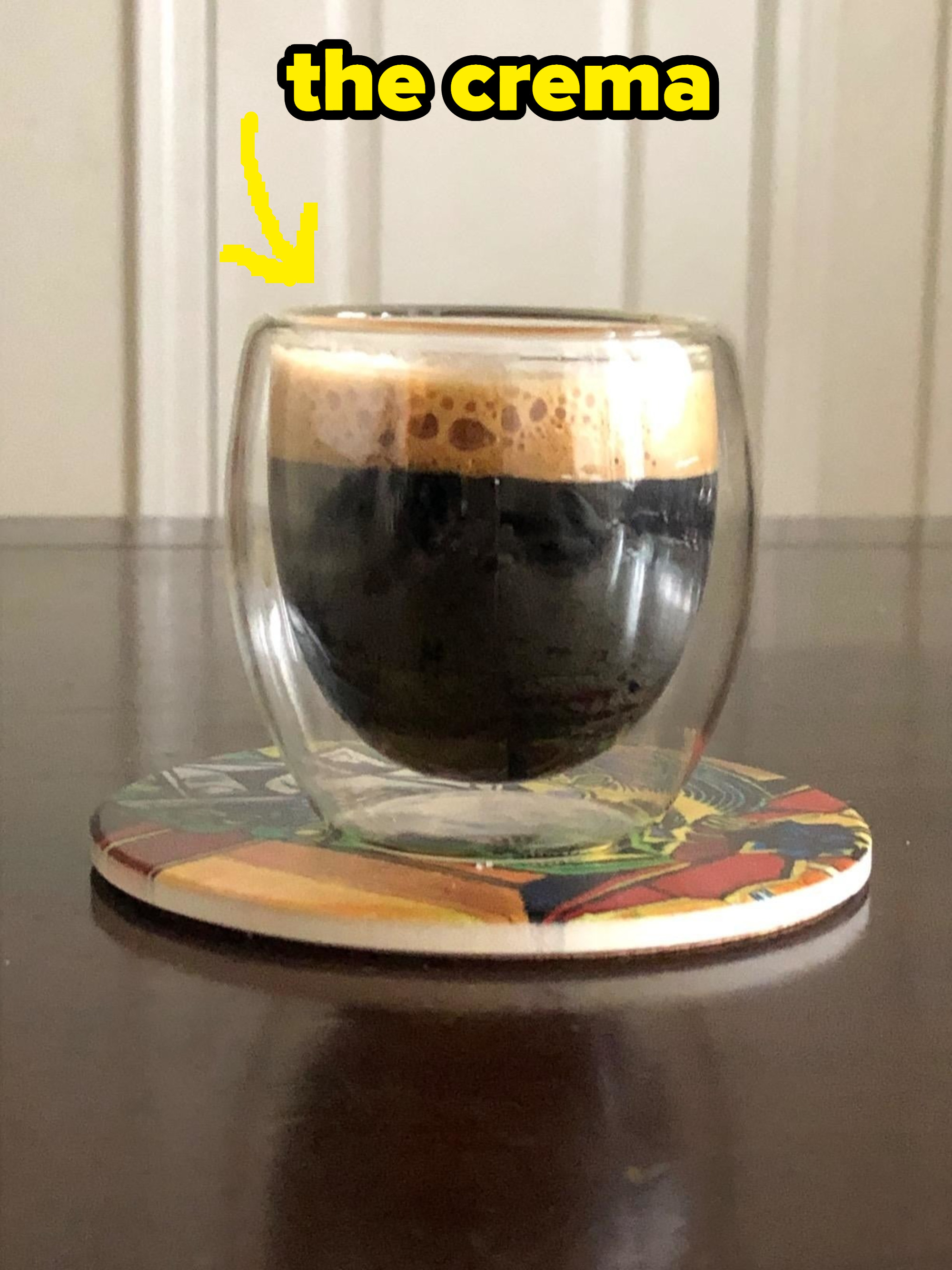 A reviewer&#x27;s coffee in a clear mug showing the crema