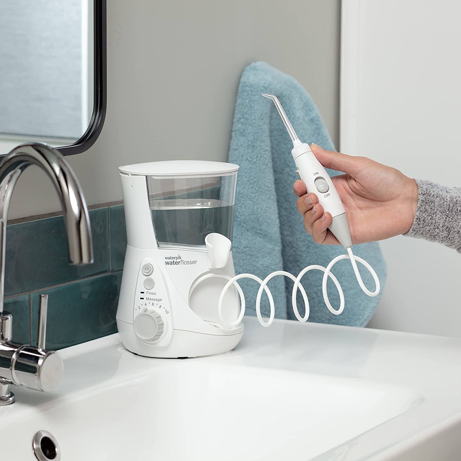 the white waterpik water flosser on a bathroom sink counter