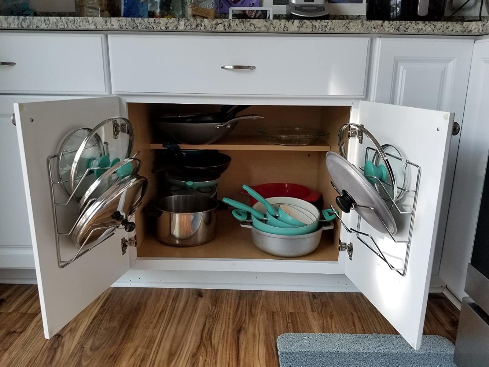 Reviewer image of two lid organizers attached to the insides of kitchen cabinet doors