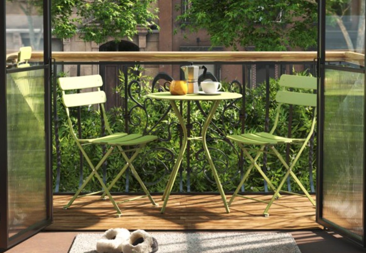 the green chair and table set on a balcony