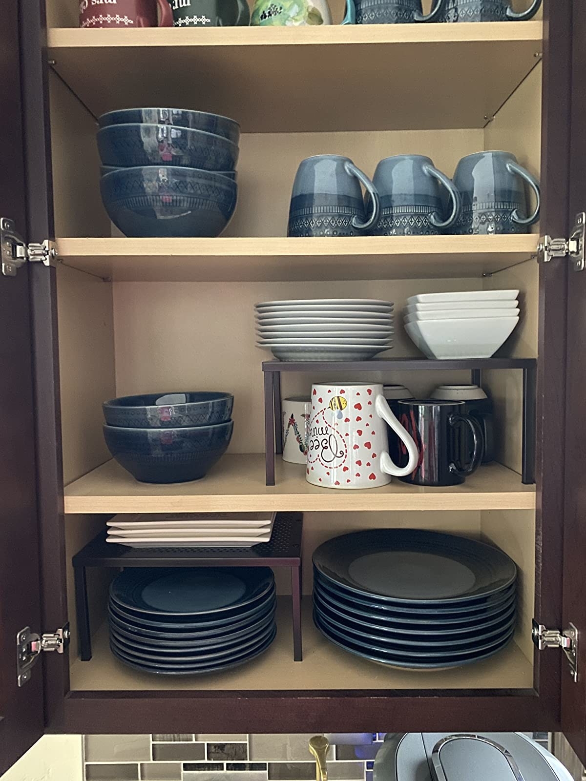 Reviewer image of two shelves used inside a kitchen cabinet with dishes