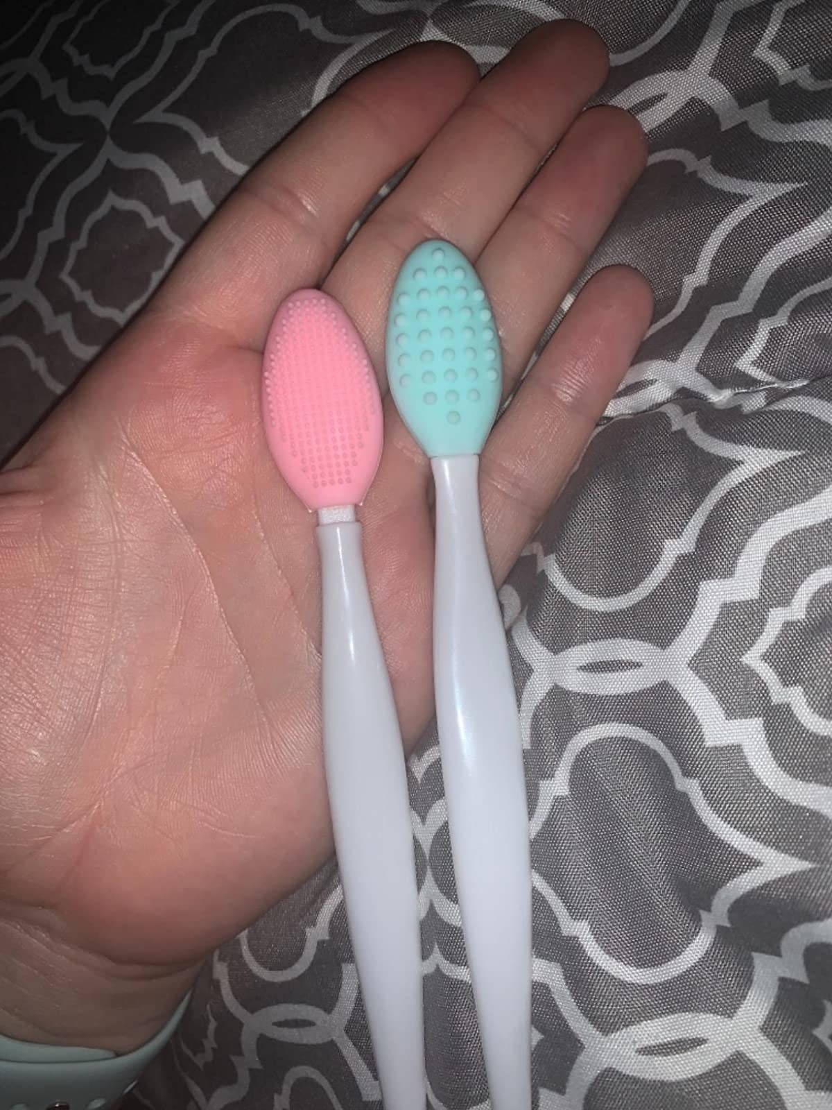 Reviewer holding pink and blue lip brushes