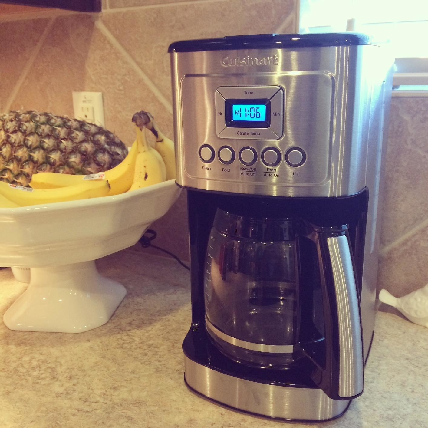 Reviewer image of coffeemaker on a countertop next to a bowl of fruit