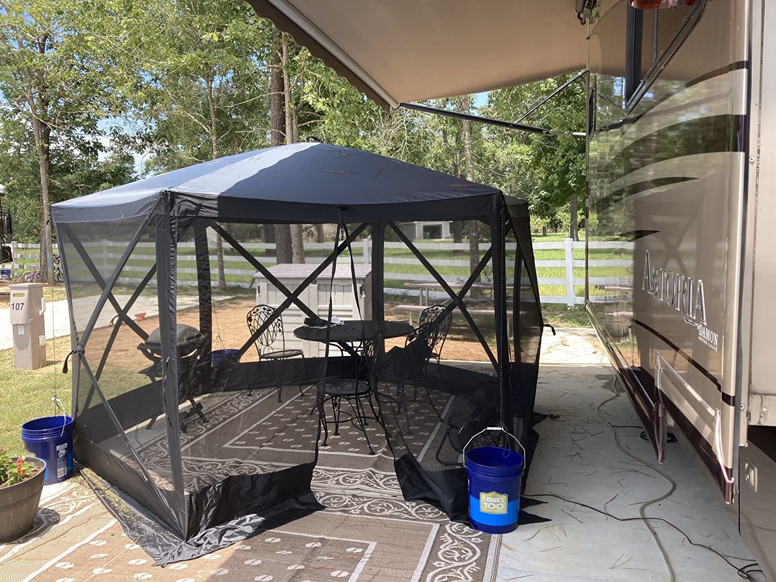 the screen tent next to a reviewer&#x27;s camping trailer