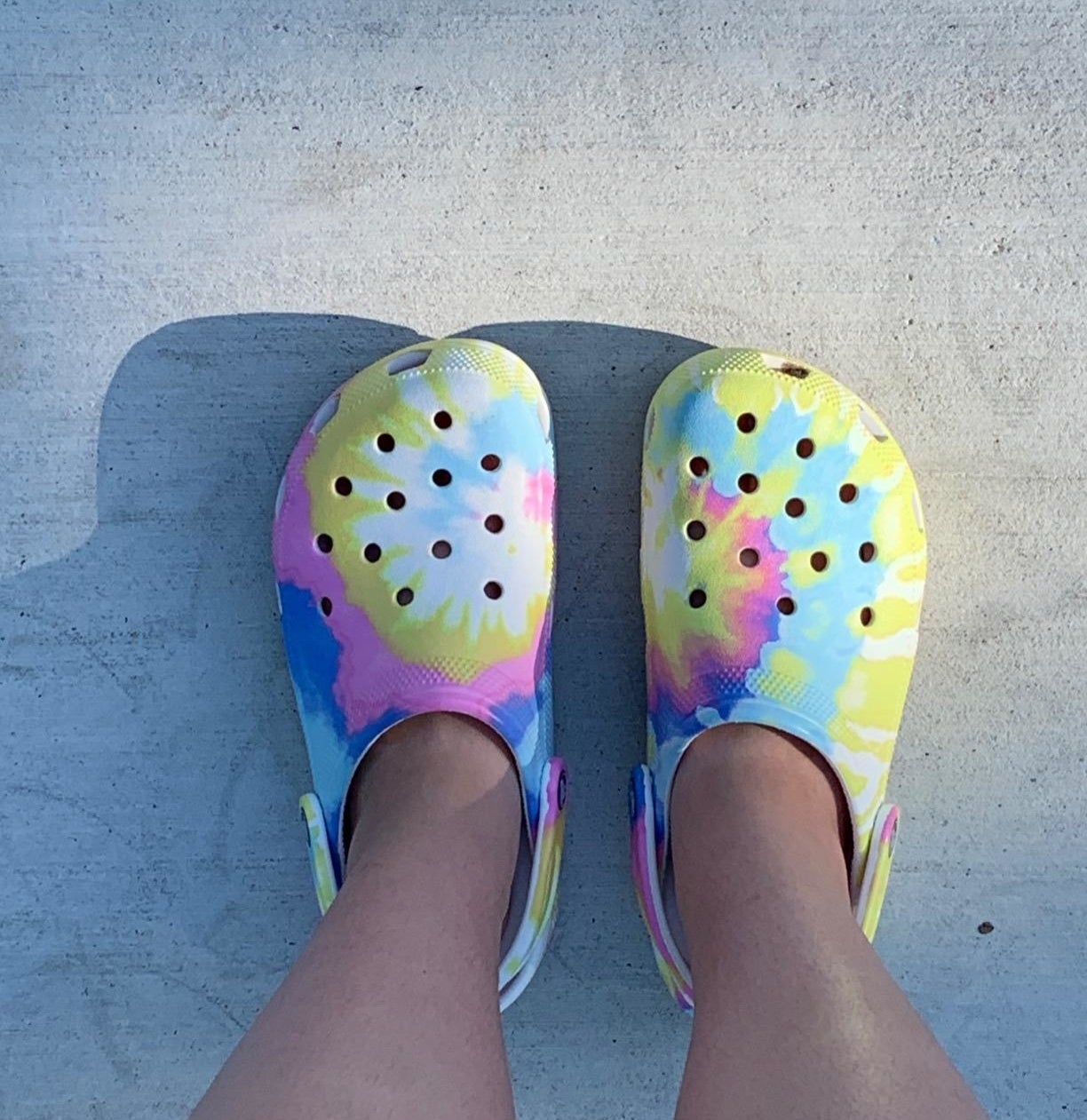a reviewer photo of someone wearing the tie dye crocs