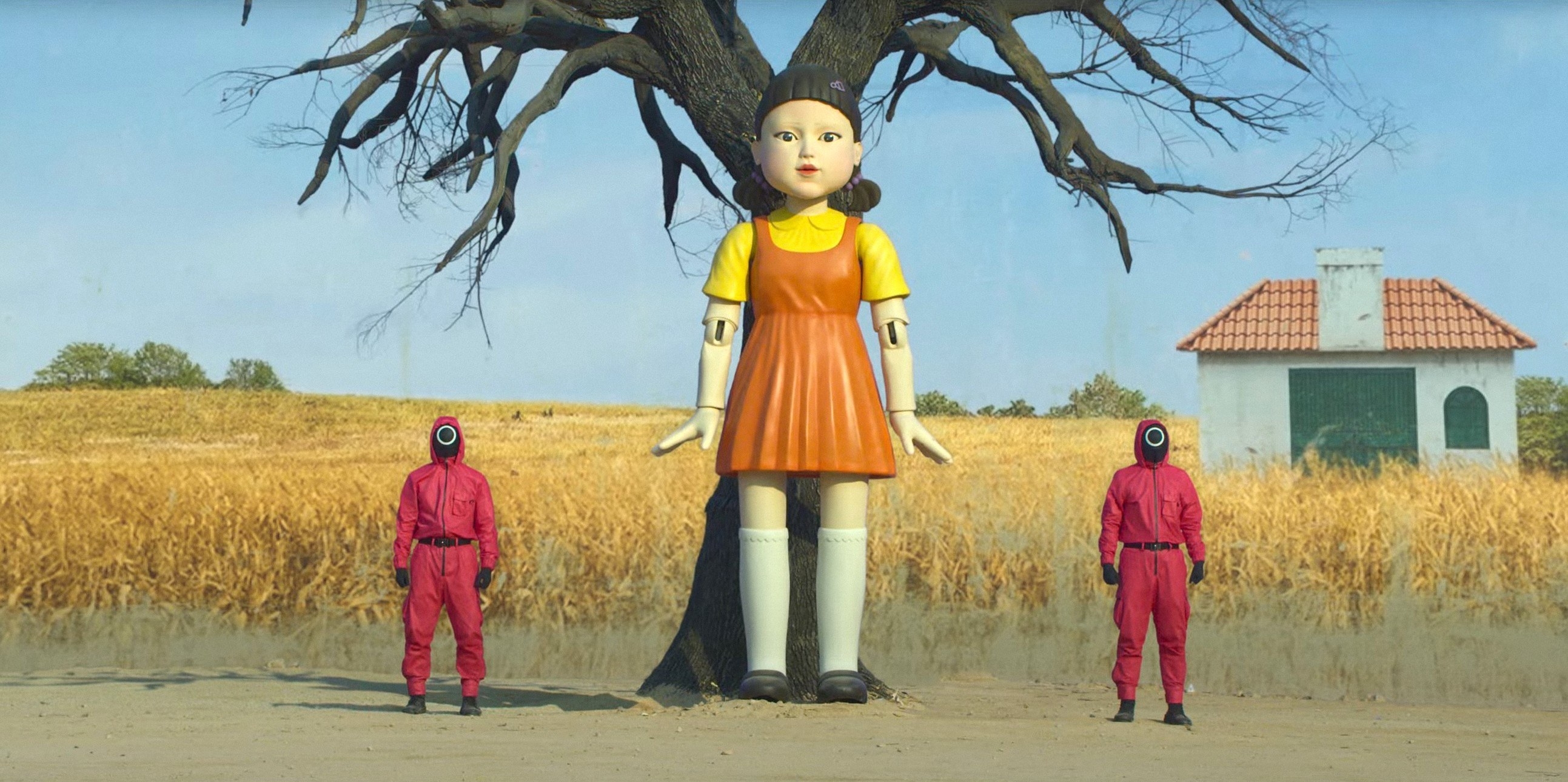 Two guards stand next to a giant doll