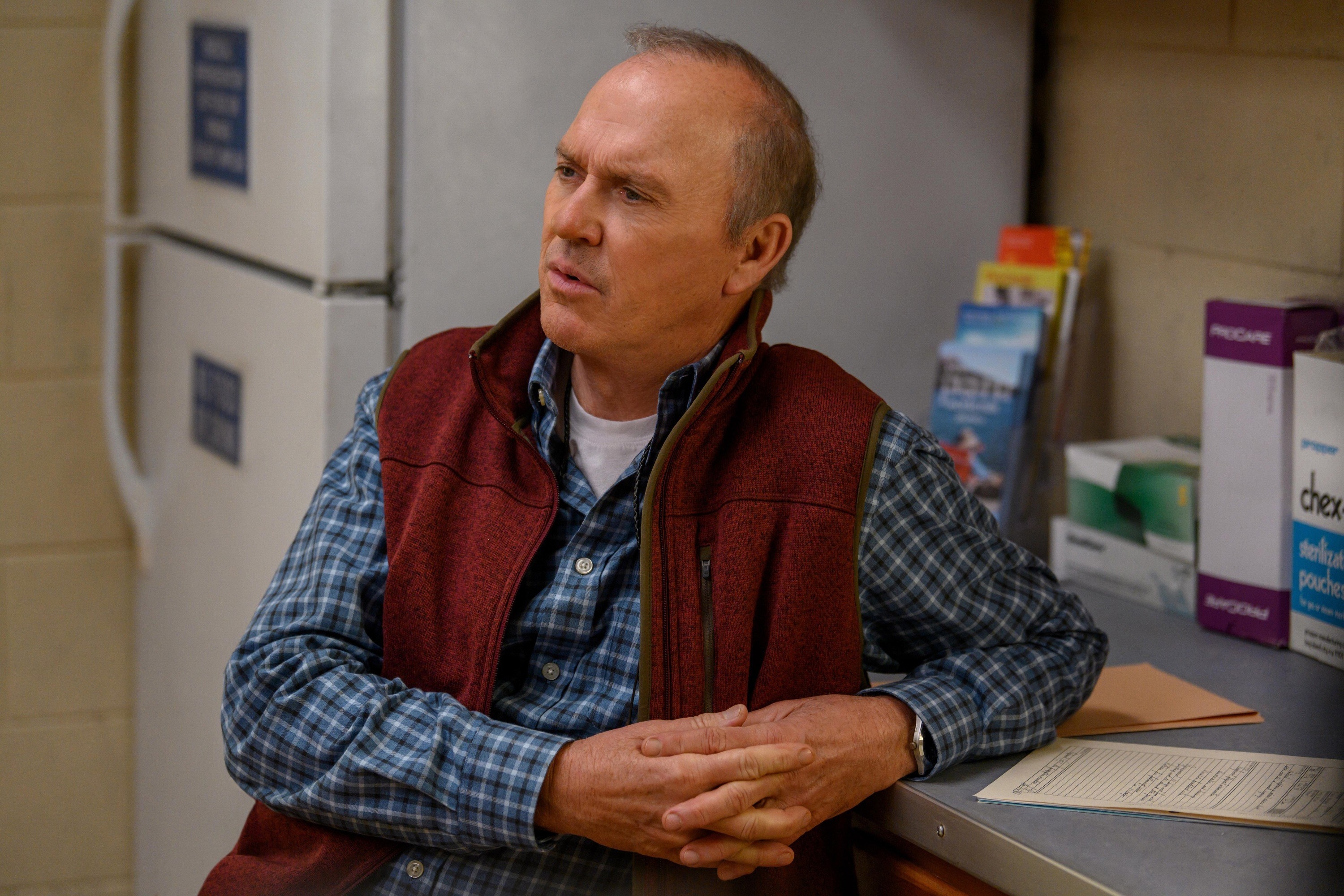 Michael Keaton leans on a counter