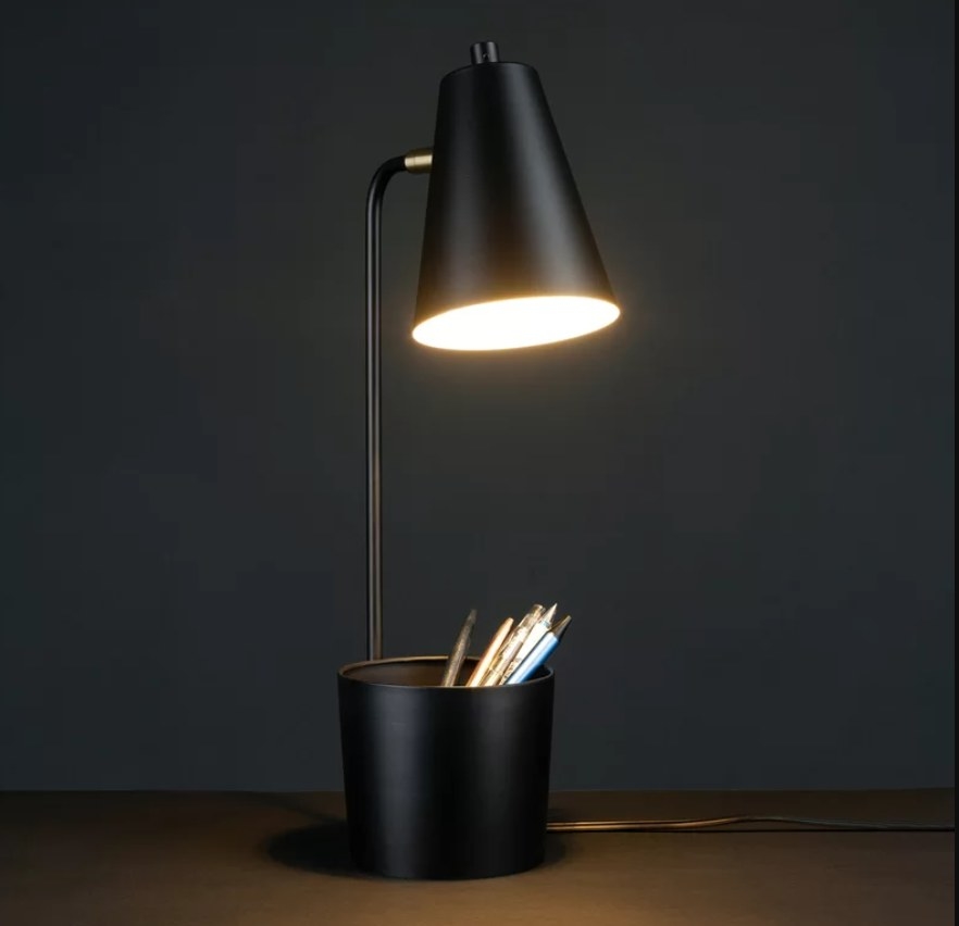 Lit lamp with pens in pot