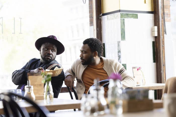 Brian Tyree Henry and Donald Glover sit in a restaurant together