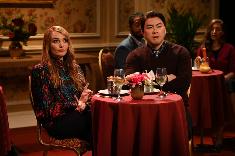 Chloe Fineman and Bowen Yang sit at a restaurant table