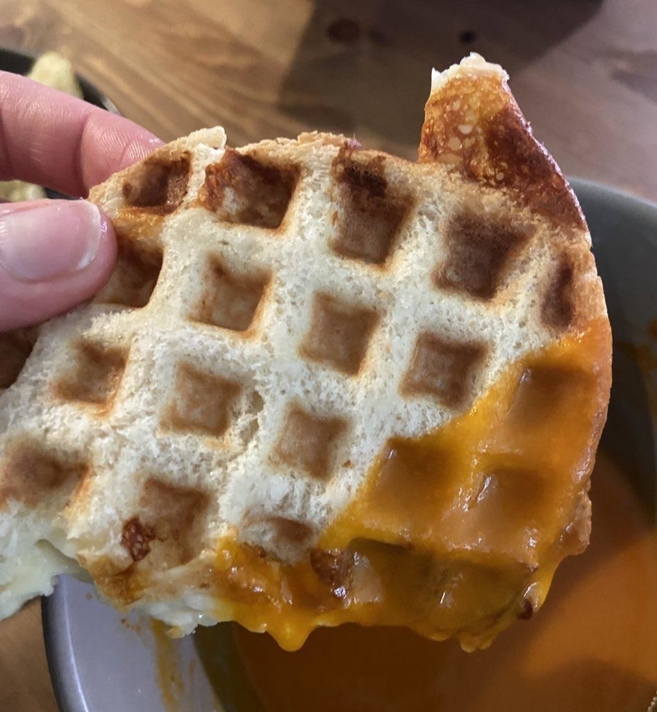A waffled grilled cheese dipped in tomato soup.