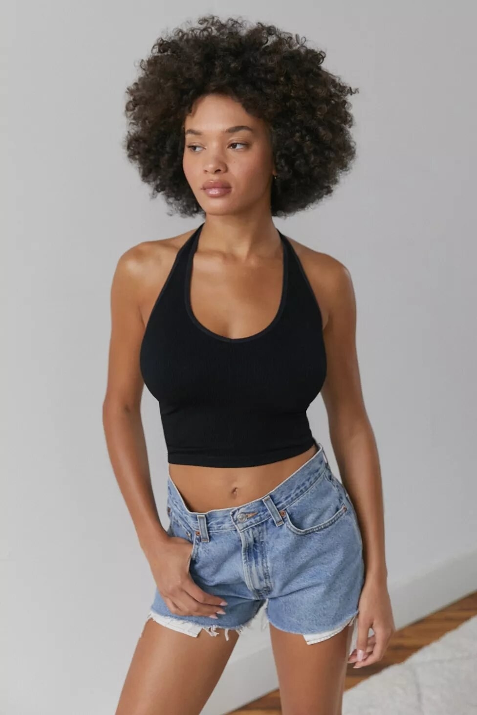 Person wearing halter bra top and jean shorts