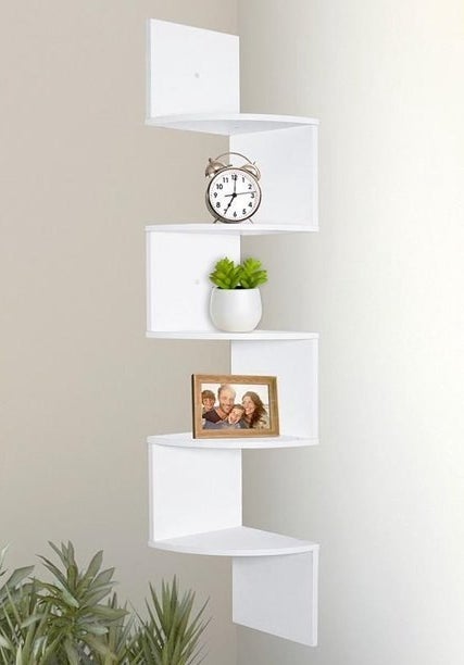 White floating shelf on wall with vase and picture frame on it