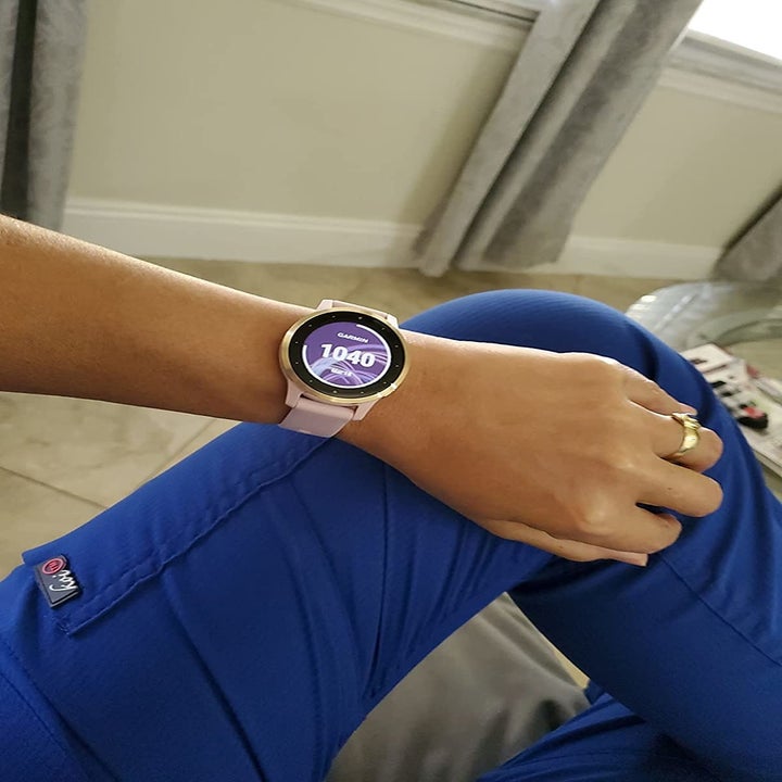 reviewer wearing the pink Garmin smartwatch on their wrist