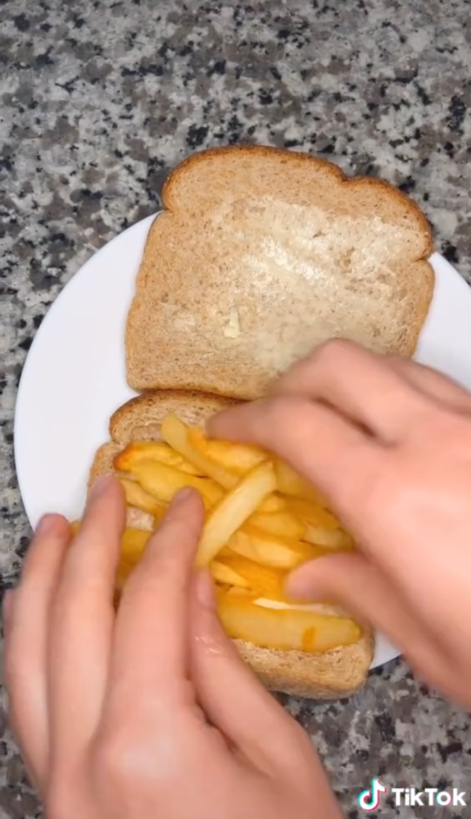 Caroline is now stacking french fries onto the buttered piece of toast