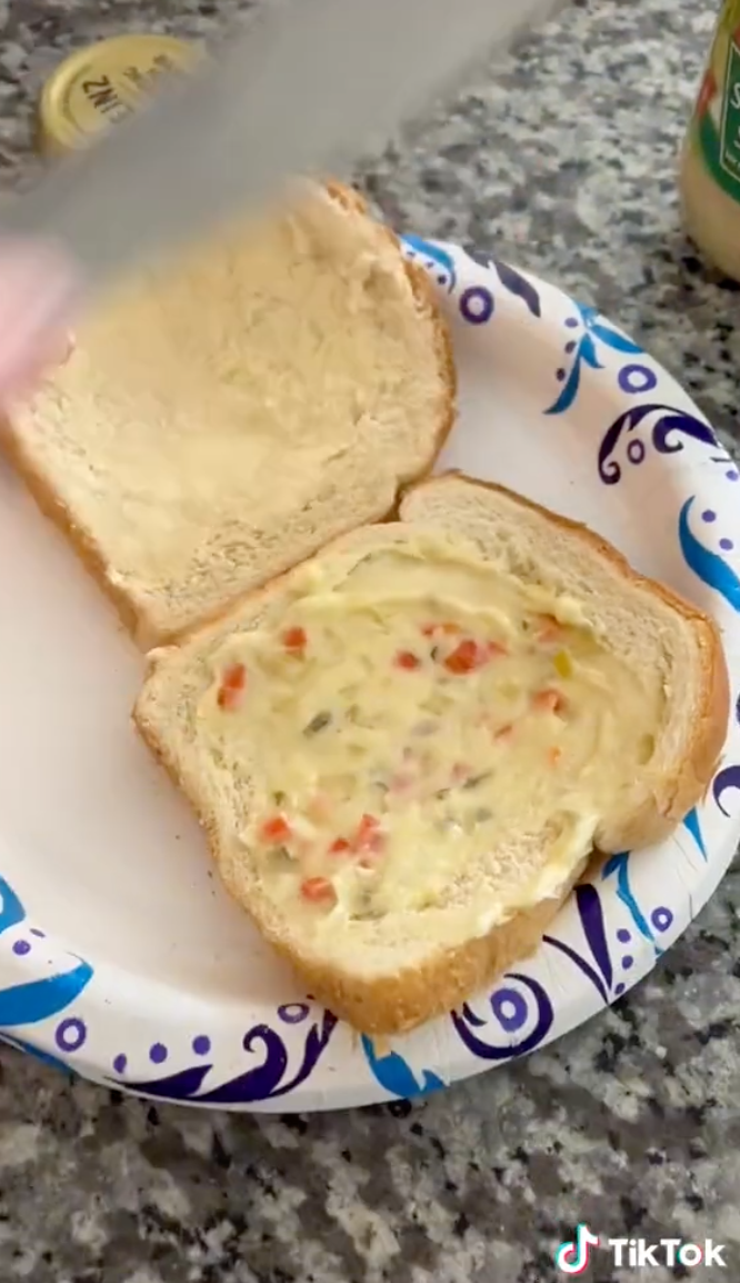 Two pieces of bread coated in a spread that has small chunks of something in it