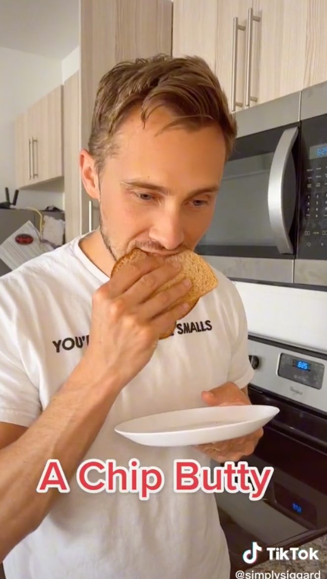Sean eating Caroline&#x27;s creation with large text on screen that says &quot;a chip butty&quot;