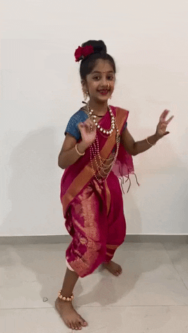 A young saree-clad girl is dancing