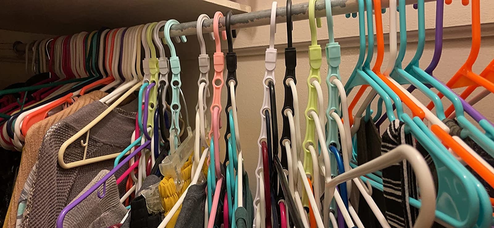 a reviewer photo that shows multiple hangers hanging from one organizer saving room for more storage