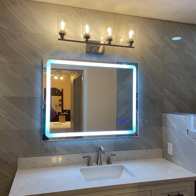 A mirror with LED lights hung horizontally