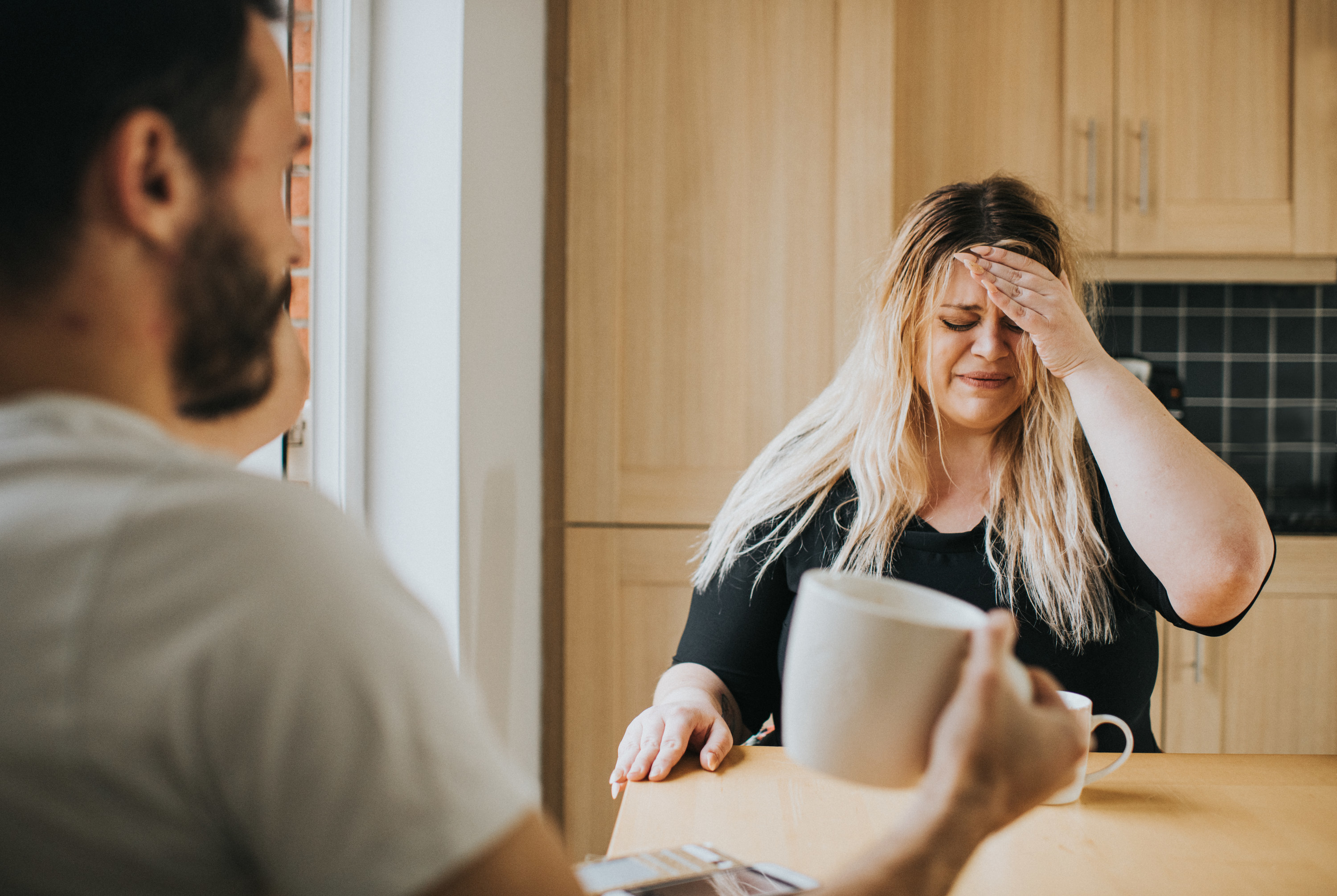 a woman looking distressed as a man looks at her