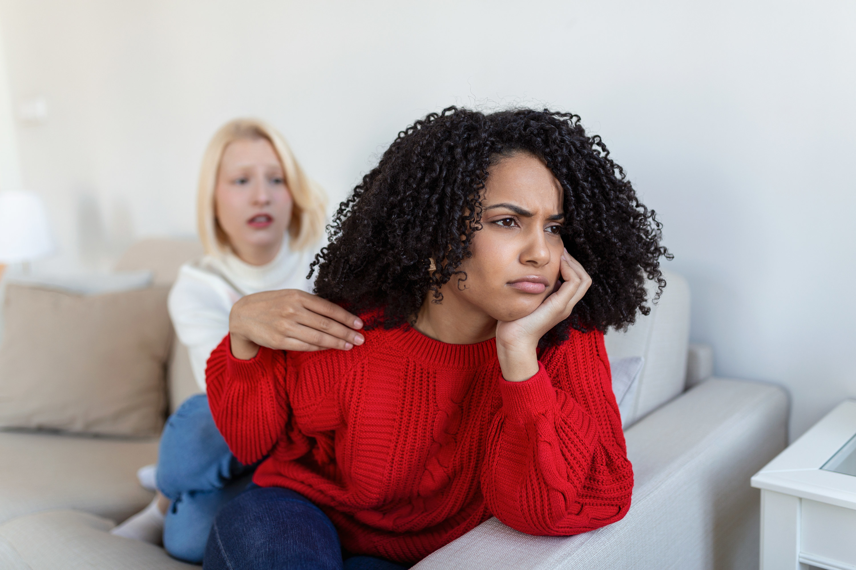 a woman looking angry and a woman behind her looking worried