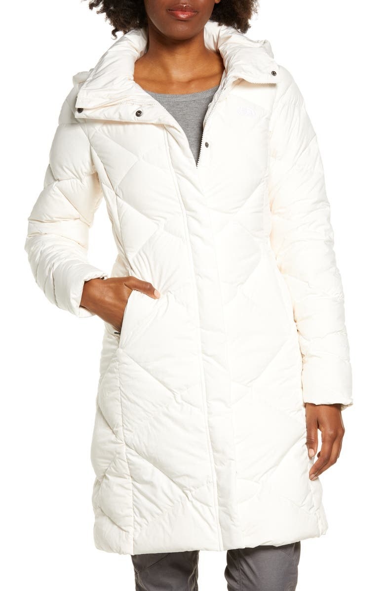 Model wearing thigh length white down parka
