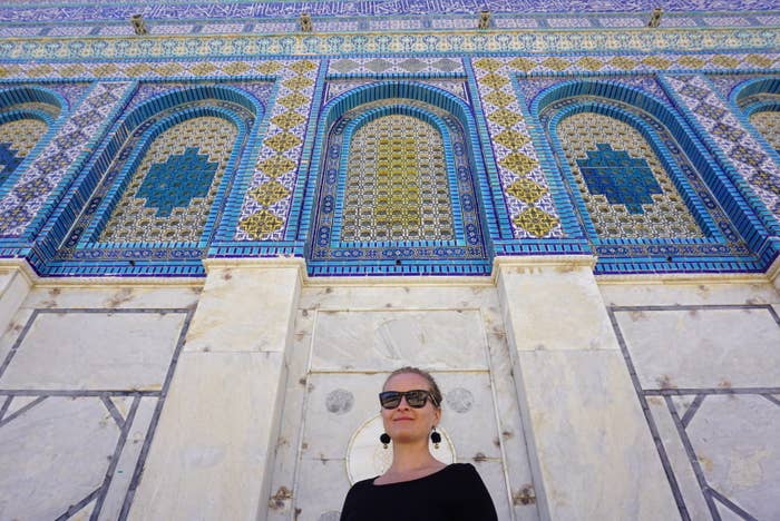 Woman in front of a white building with bright tiles