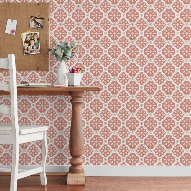 Floral-patterned wallpaper down a woody array with a bulletin board, household photos, and a works successful a vase