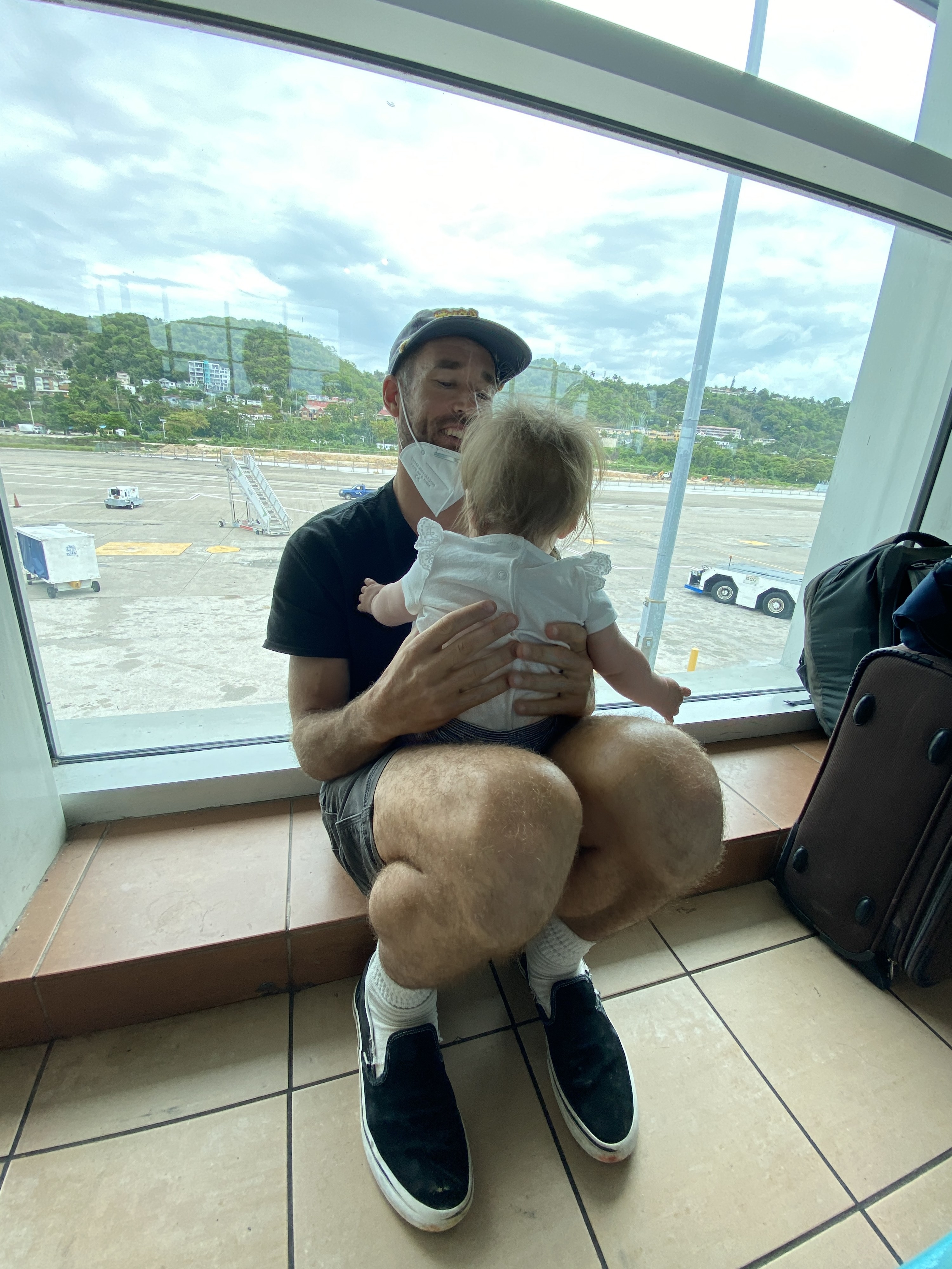 Man with baby in an airport near the windows