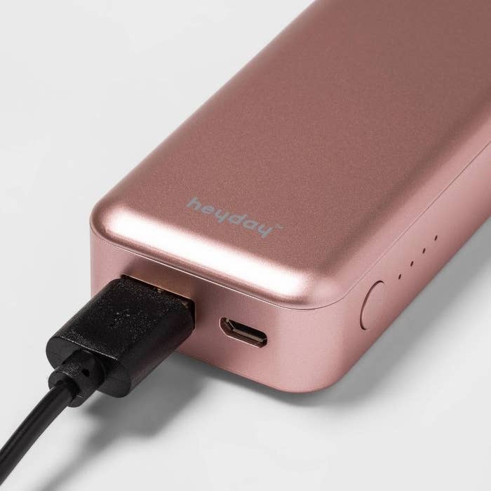 rose gold externat battery with a USB-C input and USB-A cord plugged in