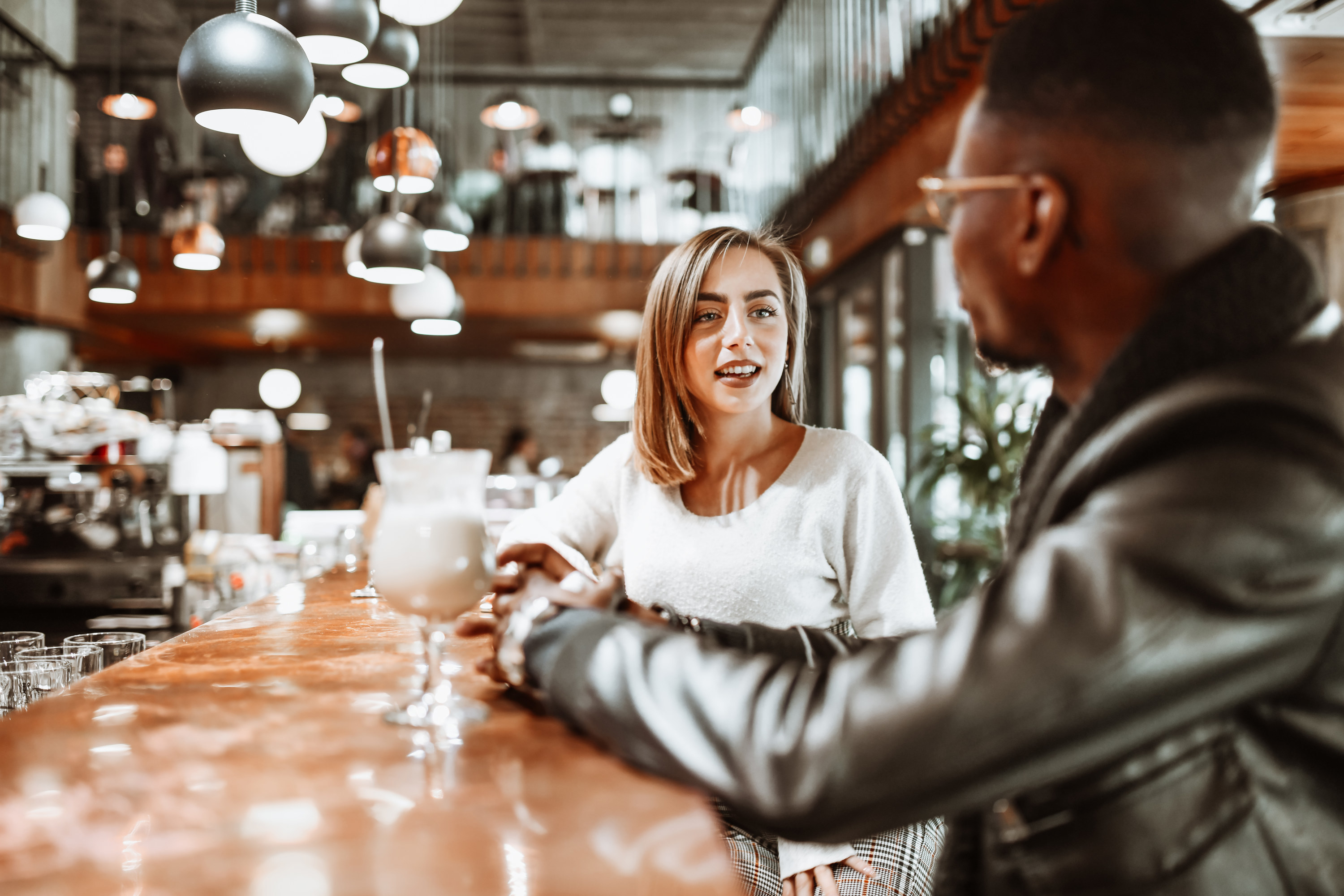 A woman sits with a man at a bar