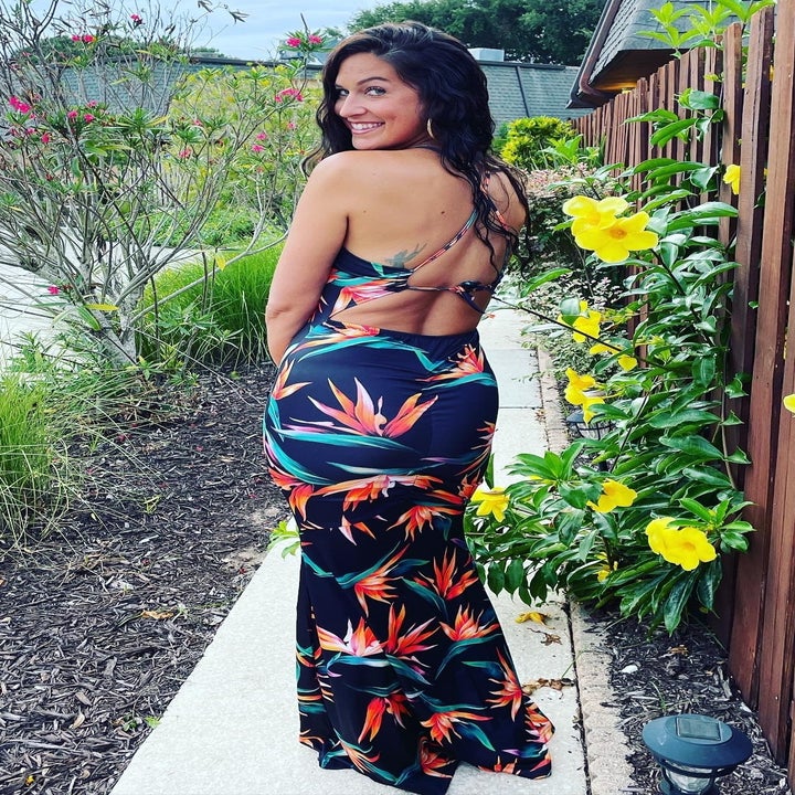 a reviewer showing the tropical print dress from the back