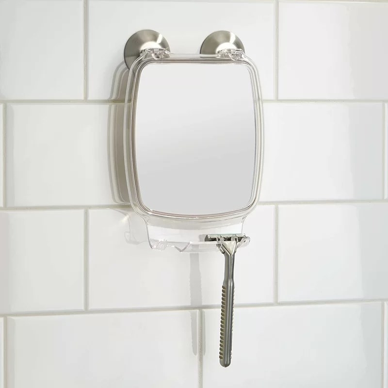 A fog-resistant bathroom mirror mounted by two suction cups