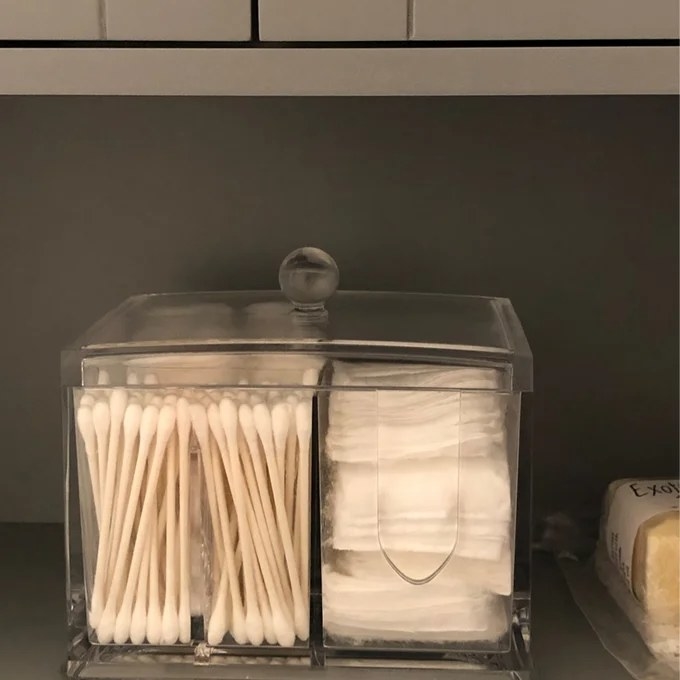 A clear storage container with gauze and q-tips