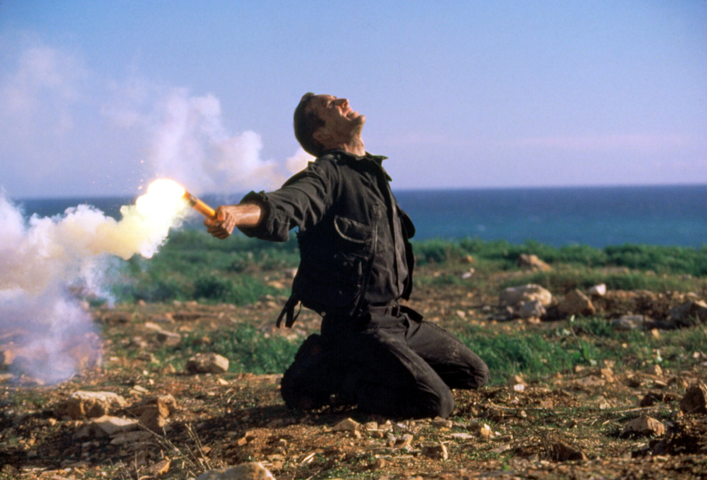 Nicolas Cage holding flares while on his knees