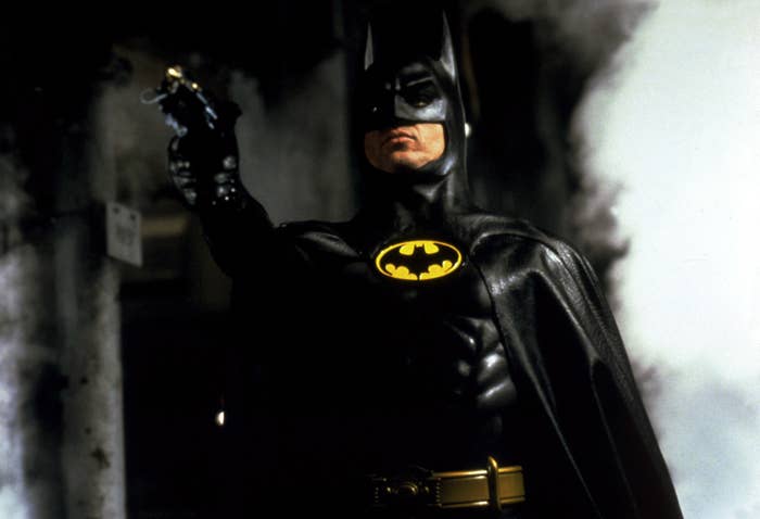 Michael Keaton as Batman pointing a weapon