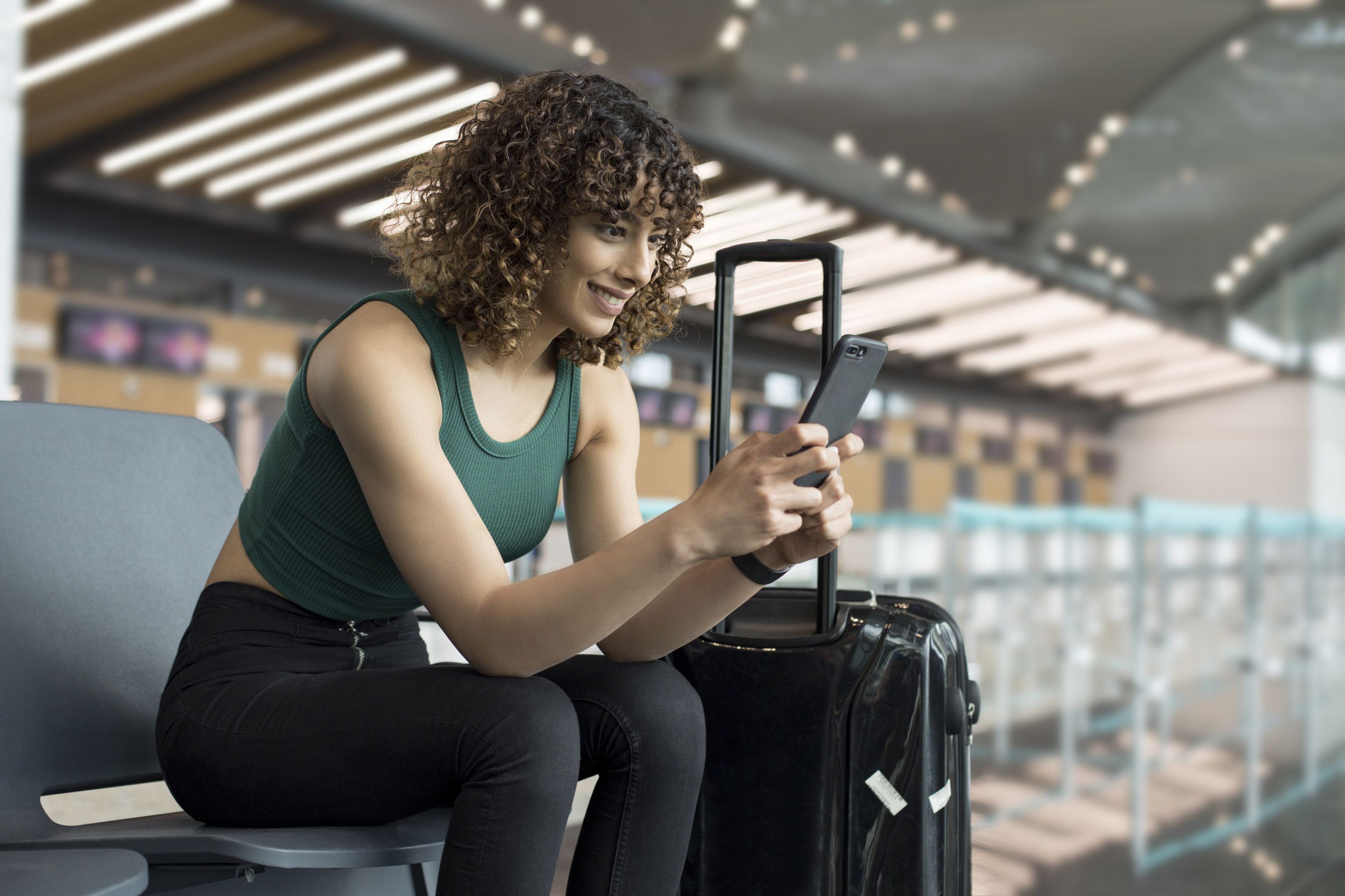 A woman texts someone while sitting in an airport