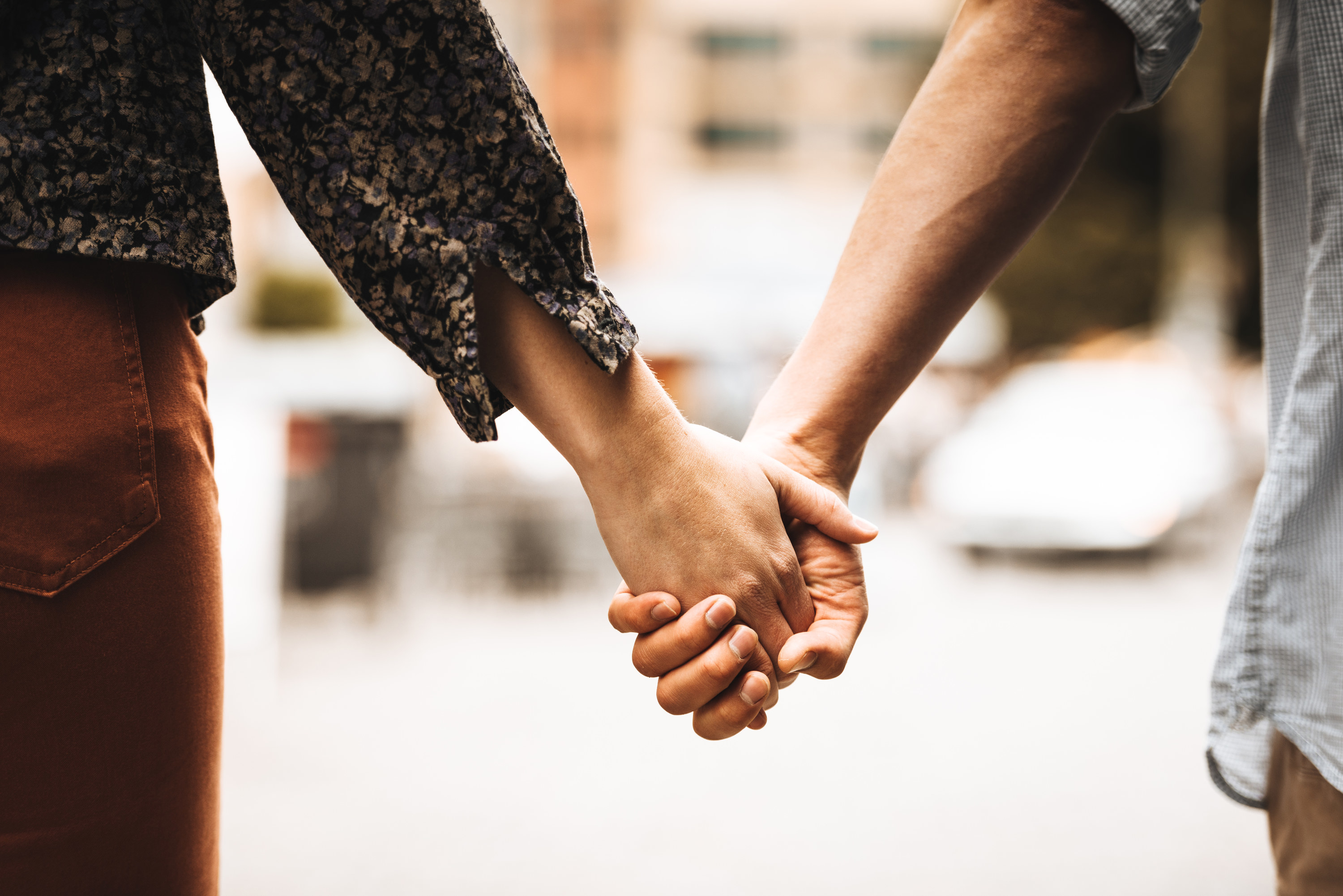 A couple holds hands as they walk together