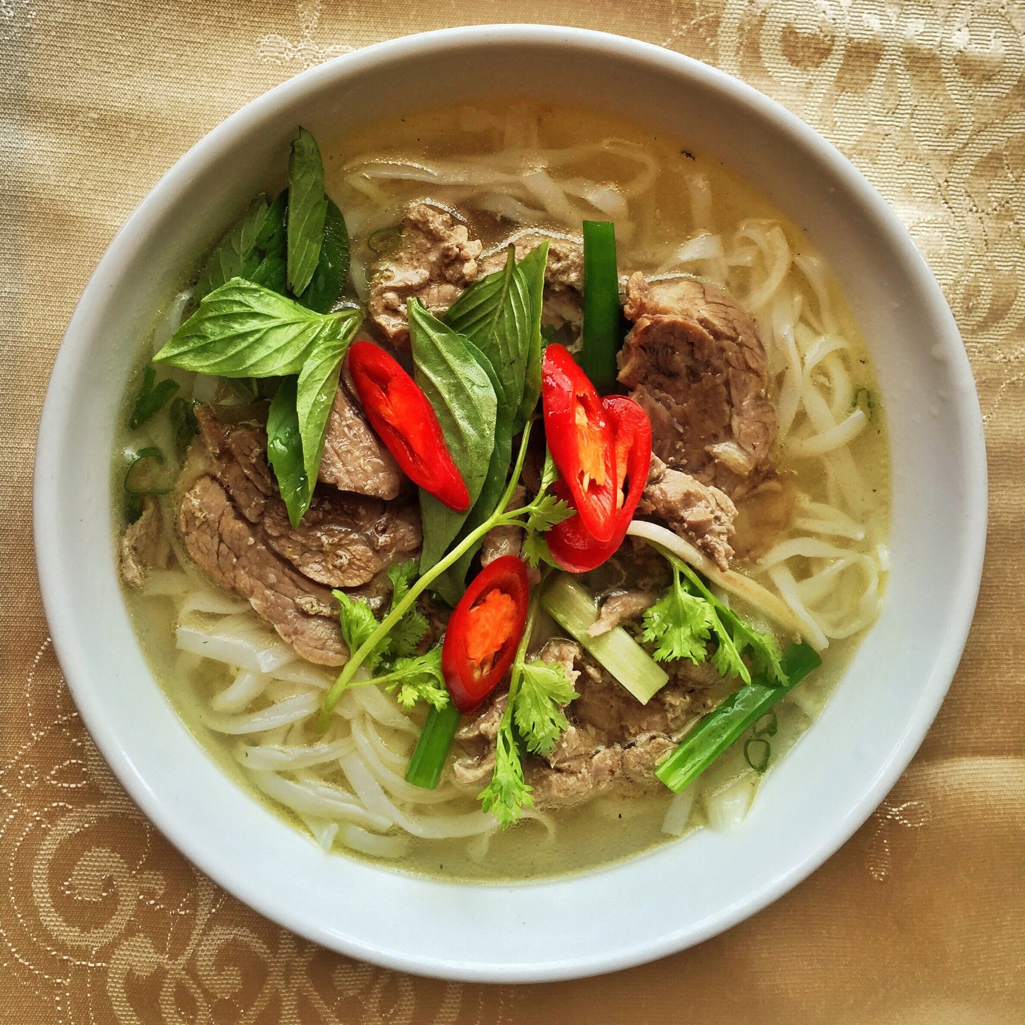 A bowl of pho with beef.