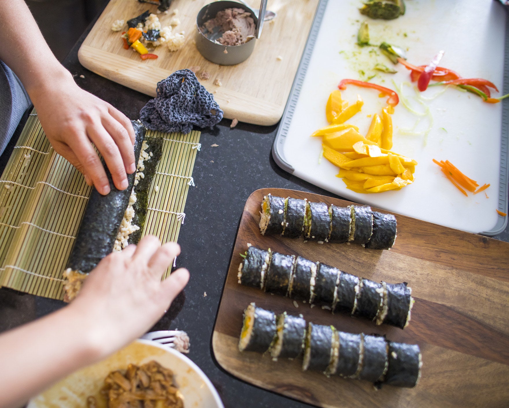 A woman rolling sushi.