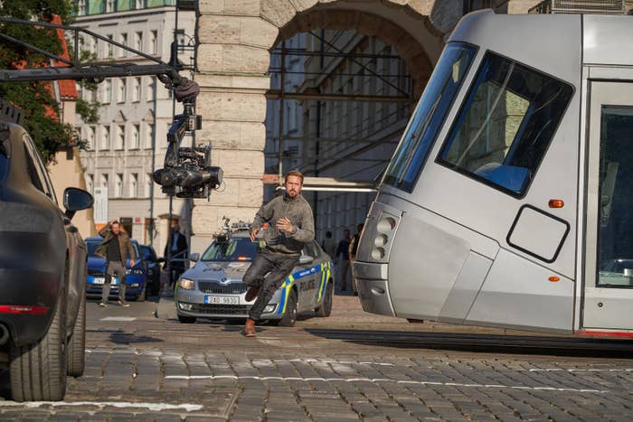 ryan gosling as sierra six running on through a street while a tram looks like it&#x27;s about to hit him