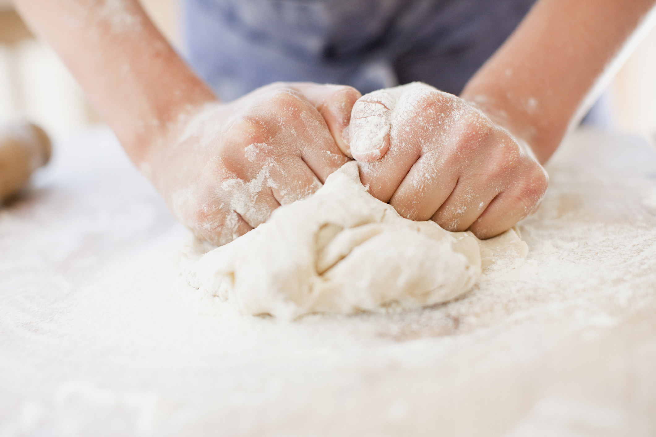 A woman kneading dough.