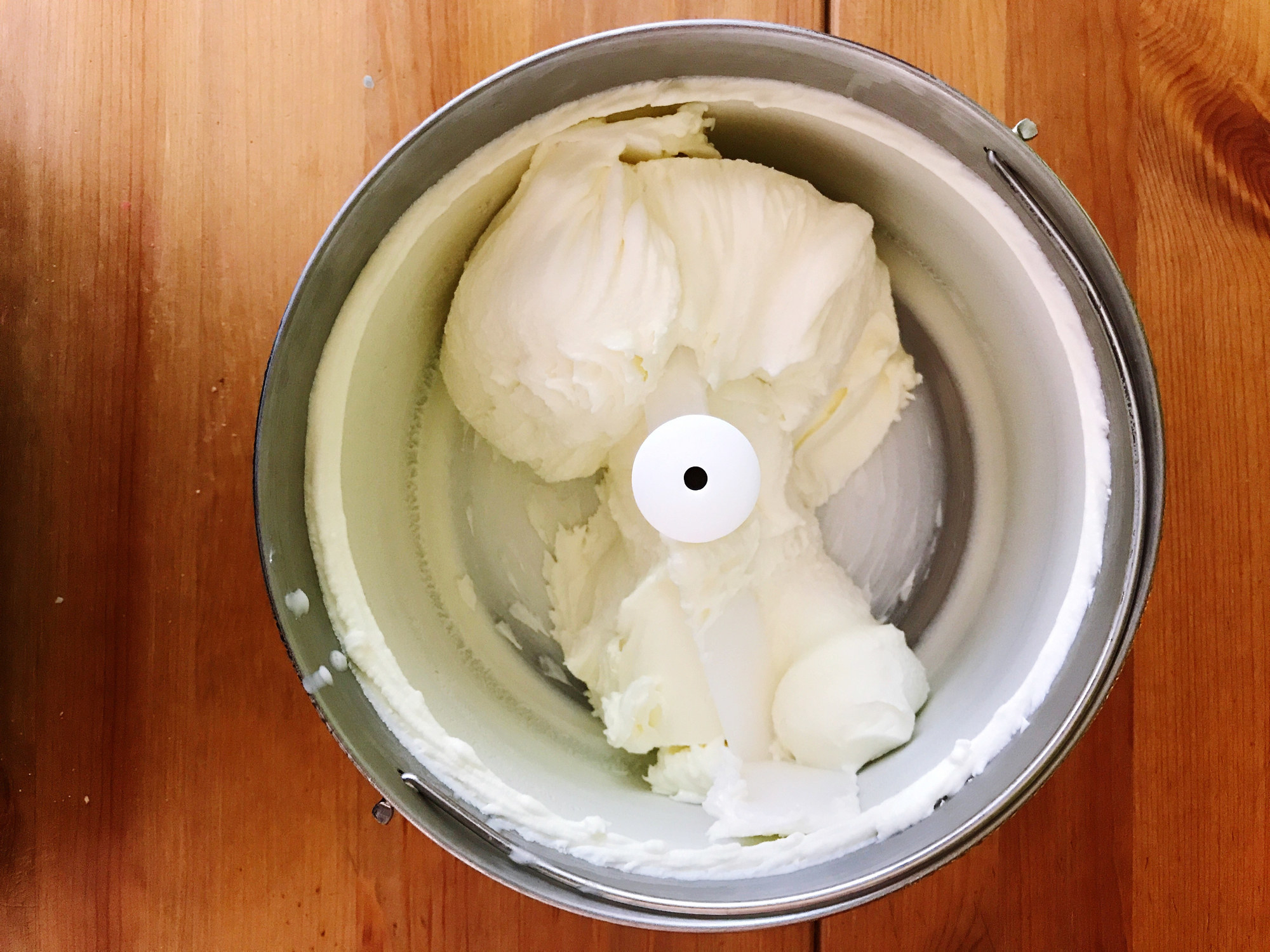 An ice cream maker filled with vanilla ice cream.
