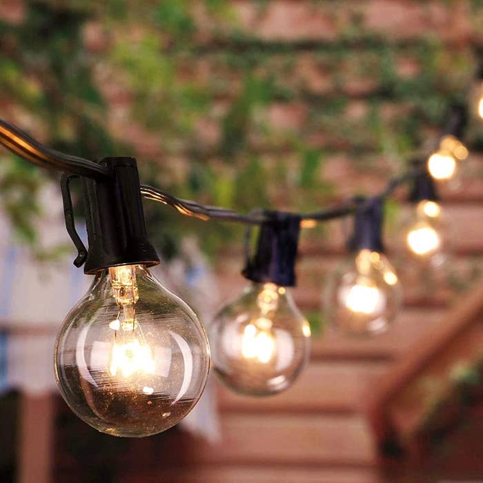 Edison bulb string lights hanging and turned on in a backyard