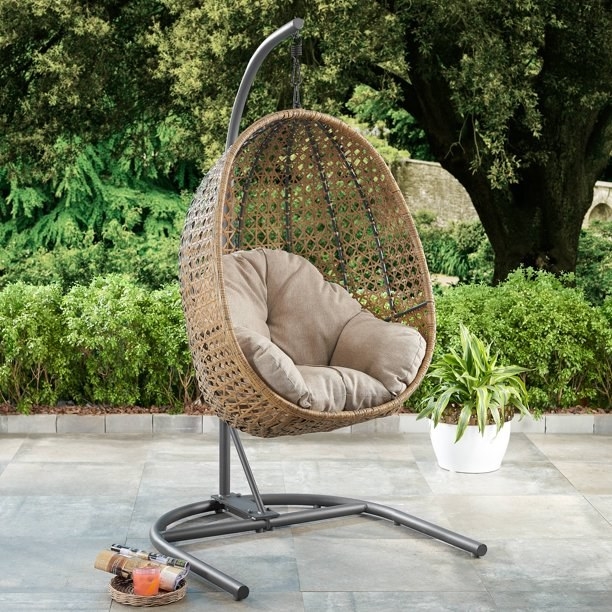 Brown egg chair with a beige cushion on a patio