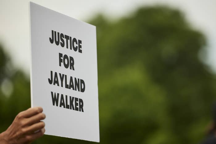 A demonstrator holds a sign during a vigil in honor of Jayland Walker